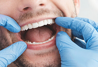 Mann lässt seine Zähne beim Zahnarzt untersuchen.